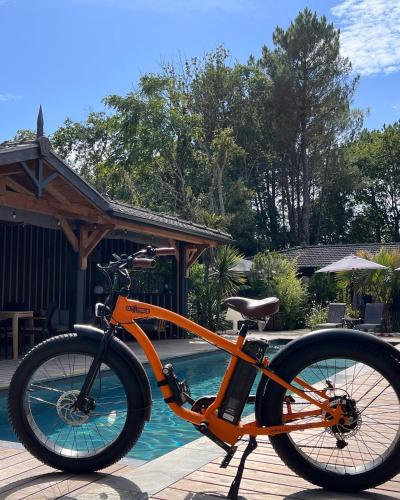 an orange bike is parked next to a pool at VillaCanau in Lacanau