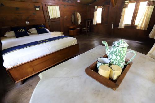 a bedroom with a bed and a table with a tray at Katumbiri Resort in Bogor