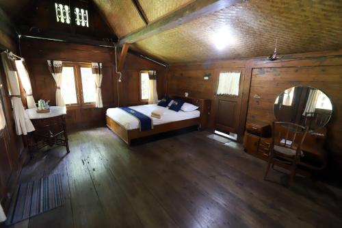 a bedroom with a bed and a table and a mirror at Katumbiri Resort in Bogor