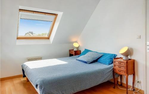 une chambre avec un lit avec des oreillers bleus et une fenêtre dans l'établissement Awesome Home In Brignogan-Plages, à Brignogan-Plage