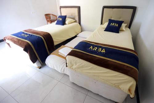 a room with two beds in a room at Katumbiri Resort in Bogor