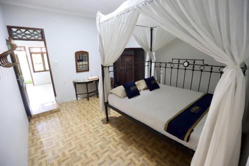 a bedroom with a bed with a canopy at Katumbiri Resort in Bogor