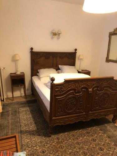 トゥルヴィル・シュル・メールにあるMaison 5 chambres, jardinet, accès plageのベッドルーム(白い枕の大きな木製ベッド付)