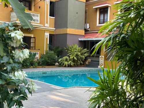 a hotel with a swimming pool in front of a building at The Majorda Pristinne Hotel in Majorda