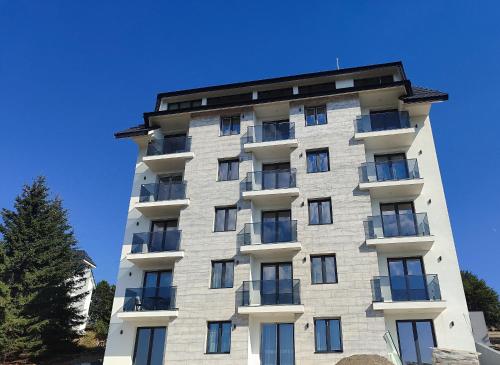 un alto condominio con un cielo blu sullo sfondo di RAS ROYAL TRESKA ESCAPE Kopaonik a Kopaonik