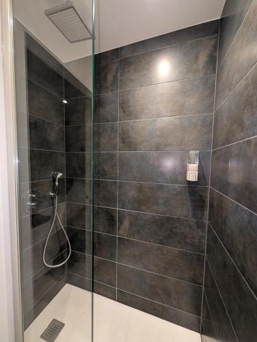 une salle de bain avec une douche avec une porte vitrée dans l'établissement LE YAMA, à Chamonix-Mont-Blanc