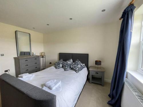 a bedroom with a bed with pillows and a mirror at Foxhall Farm in Thirsk