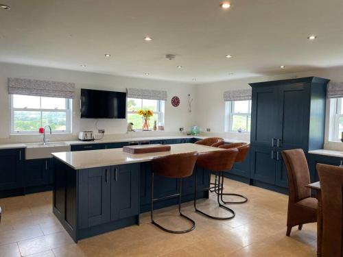 a kitchen with blue cabinets and a island with bar stools at Foxhall Farm in Thirsk