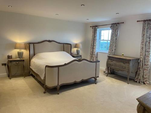 a bedroom with a large bed and a window at Foxhall Farm in Thirsk