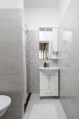 a white bathroom with a sink and a toilet at Villa Vuka in Omišalj