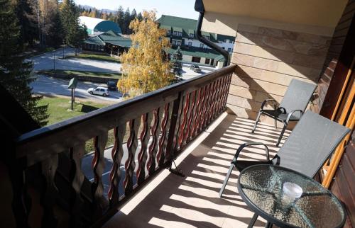 a balcony with two chairs and a table and a street at Apartman Iva in Nova Varoš