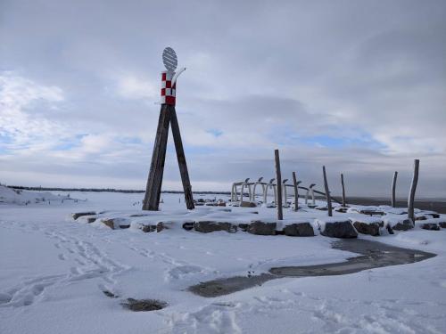 a windmill in the snow on a beach at Drei-Insel-Blick Neßmersiel in Neßmersiel