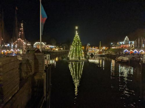 a christmas tree in the water at night at Drei-Insel-Blick Neßmersiel in Neßmersiel