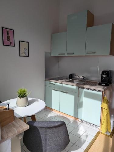 a kitchen with white cabinets and a white table and chairs at Appartement Napoleon in Meißen