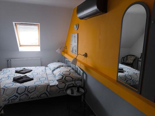 a small bedroom with two beds and a mirror at Penzion Miromar in Podivín