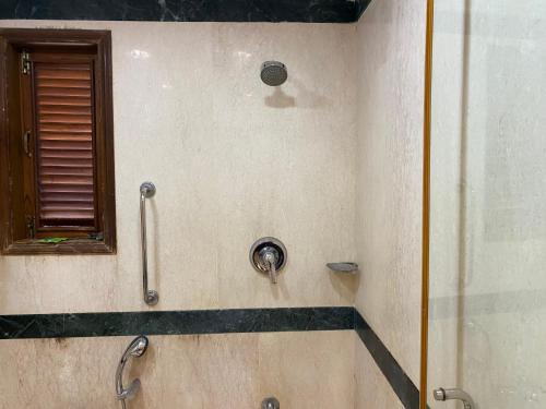 a shower in a bathroom with a glass door at 1BHK Luxury Homestay In Betalbatim South Goa 1km from the Beach in Marmagao