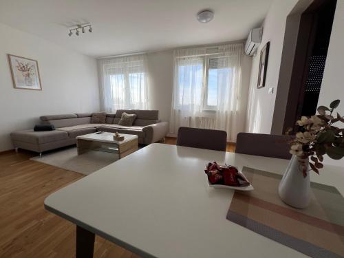 a living room with a white table and a couch at Cozy Apartment Anna in Subotica