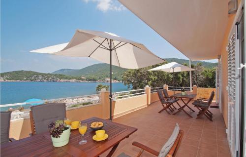 a patio with a table and an umbrella at Holiday Home Zastrazisce With Sea View 04 in Selca kod Bogomolja