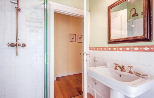 a white bathroom with a sink and a mirror at Beautiful Home In Rapolano Terme Si in Rigomagno