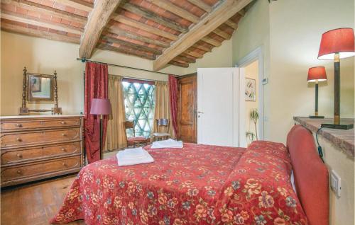 a bedroom with a bed with a red bedspread at Beautiful Home In Rapolano Terme Si in Rigomagno