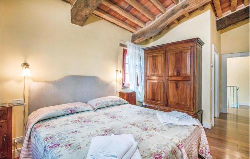 a bedroom with a large bed and a wooden cabinet at Beautiful Home In Rapolano Terme Si in Rigomagno
