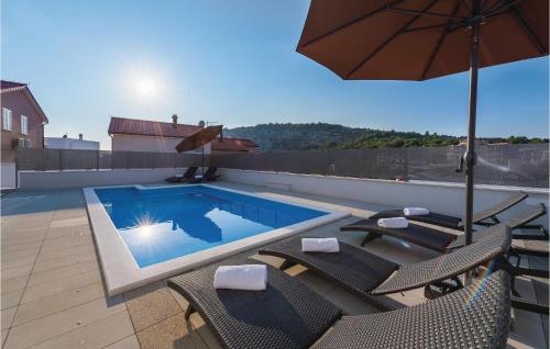 a swimming pool with chairs and an umbrella on a roof at Three-Bedroom Holiday Home In Razanj in Ražanj