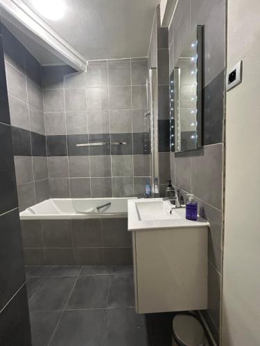 une salle de bain avec un lavabo et une baignoire dans l'établissement Appartement Cosy quartier Champs Élysées, à Paris
