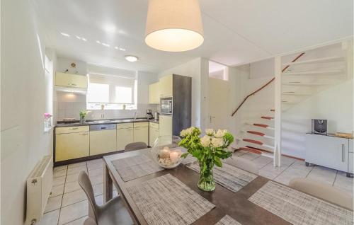 a kitchen and dining room with a vase of flowers on a table at Oesterbaai 8E2 in Wemeldinge