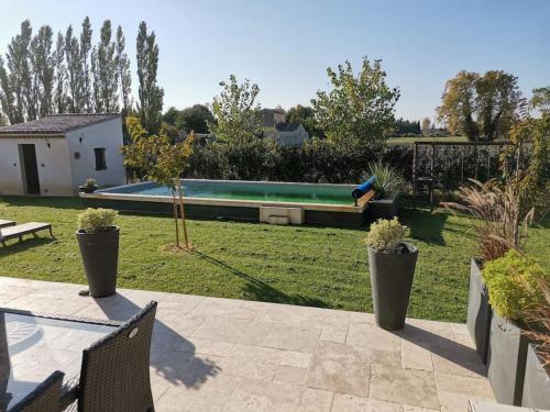un oiseau se tient dans une cour à côté d'une piscine dans l'établissement Grande maison avec jardin clos et piscine, à Courthézon