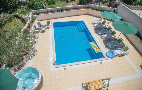 an overhead view of a swimming pool with chairs and umbrellas at Pet Friendly Home In Zagvozd With Wifi in Zagvozd