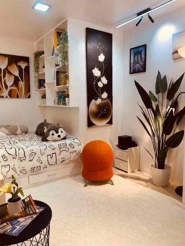 1 dormitorio con 1 cama y 1 silla naranja en The White Haven In Clark ENTIRE HOUSE, en Ángeles