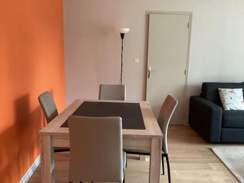 une table à manger avec des chaises et un canapé bleu dans l'établissement Appartement 200m de la plage, à Tourgéville