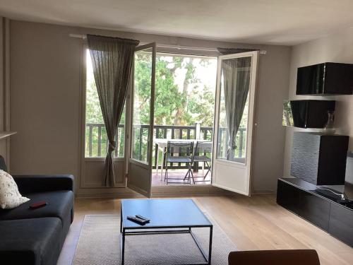 un salon avec un canapé et une table dans l'établissement Appartement 200m de la plage, à Tourgéville