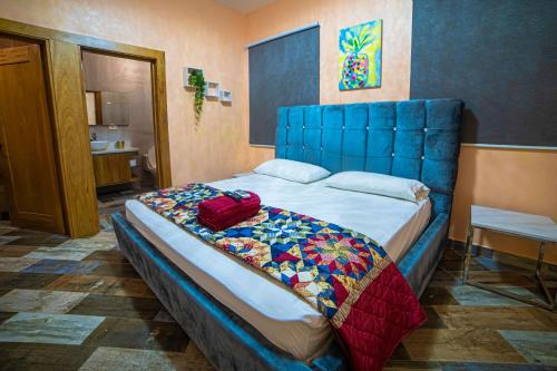 a bed with a blue headboard in a room at Villa con piscina Verdana SFM in San Francisco de Macorís