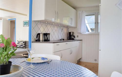 a kitchen with a table with a blue and white table cloth at Two-Bedroom Holiday Home In Dronningmolle in Dronningmølle
