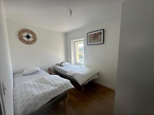 deux lits dans une petite pièce avec une fenêtre dans l'établissement Location maison de vacances Concarneau - 4 personnes, à Concarneau