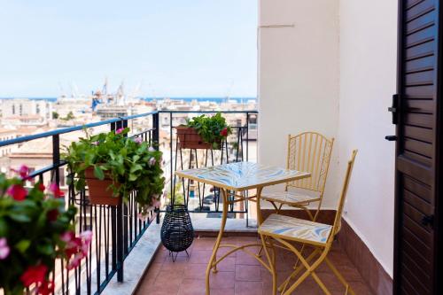 a balcony with a table and chairs and flowers at Politeama Charming Apartment in Palermo