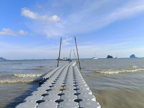 a pier in the ocean with boats in the water at Leam Sai Bungalows Koh Yao Noi in Ko Yao Noi