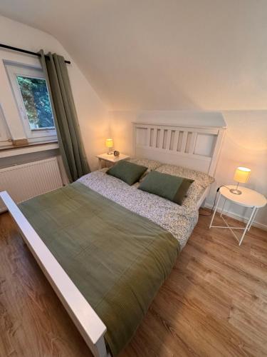 a bedroom with a large bed and a window at Ruhrtraum Kettwig Ferienwohnung am Fluss in Essen