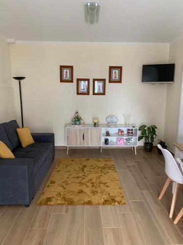 a living room with a blue couch and a tv at Grannys House in Angra do Heroísmo
