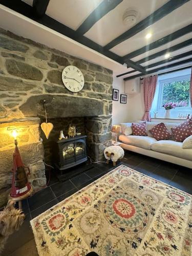 a living room with a stone fireplace and a couch at Love Lane Cottage Dolgellau in Dolgellau