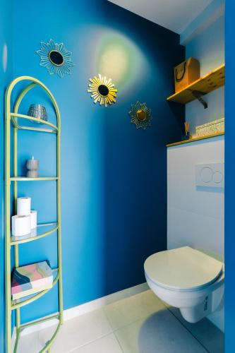 - une salle de bains bleue pourvue de toilettes et de 2 vignettes solaires dans l'établissement Au jardin Ginkgo, à Quimper