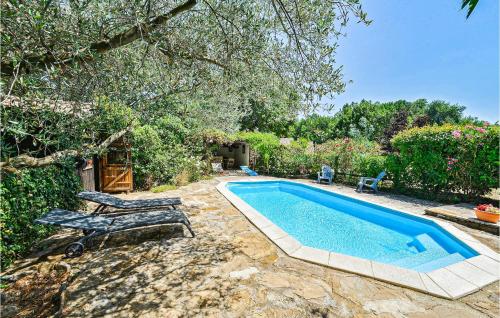 a swimming pool with two lounge chairs next to it at Les Oliviers in Vinezac