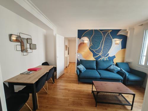 een woonkamer met een blauwe bank en een tafel bij View sur la Seine in Parijs