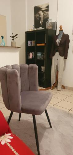 une chaise brune dans une pièce avec mannequin dans l'établissement Studio cosy Bassens 33530, à Bassens