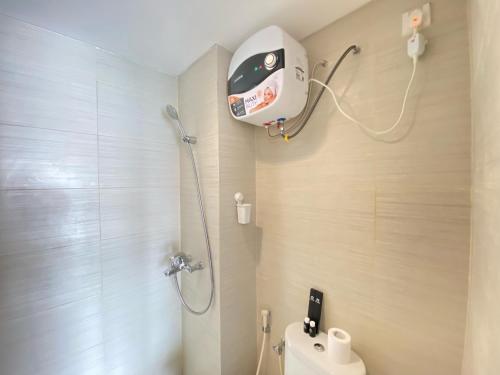 a bathroom with a shower with a toilet and a shower head at Beautiful and Clean 2BR Apartment at Gateway Pasteur Bandung By Travelio in Bandung