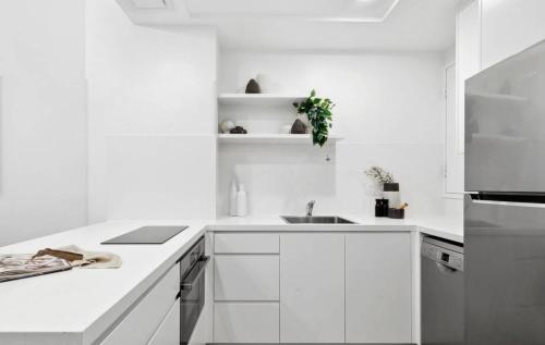 a white kitchen with white cabinets and a sink at Cliveden on Bridge in Sydney
