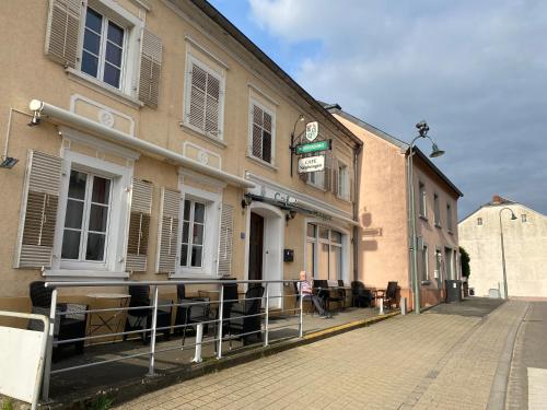 a woman sitting in front of a building at Un der Attert - Céline's Loft - Luxembourg in Boevange-sur-Attert
