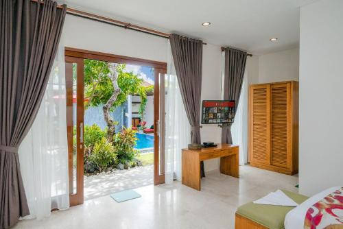 a bedroom with a bed and a sliding glass door at Delight ART Villas in Seminyak