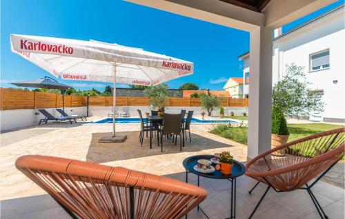 a patio with chairs and a table and an umbrella at Beautiful Apartment In Donje Rastane in Donje Raštane